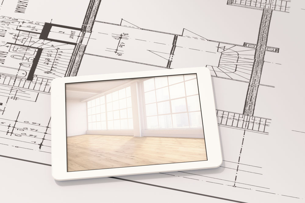 Ritning som ligger på bordet med en iPad som visar resultatet av ett rum